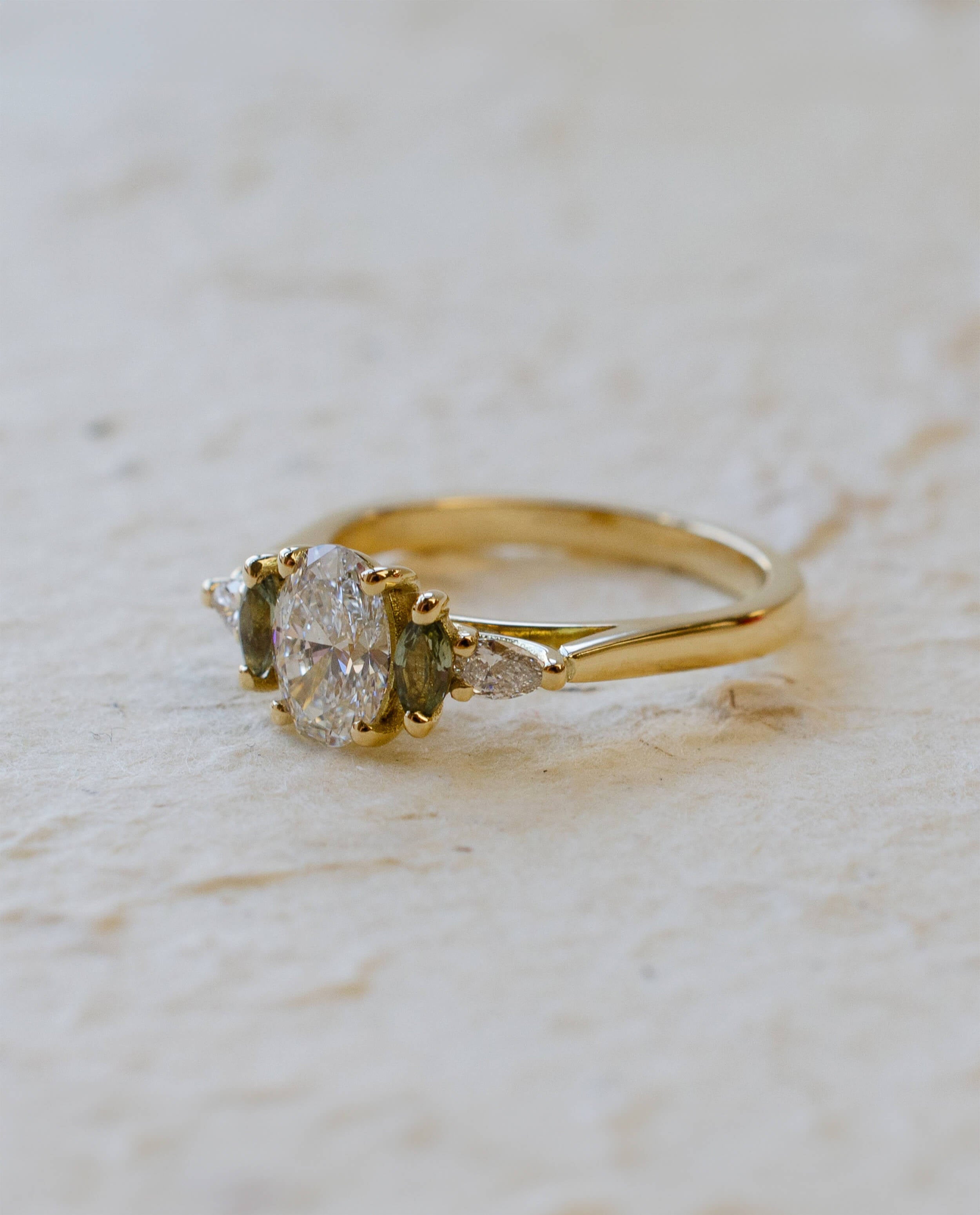 five stone engagement ring with oval lab-grown diamond and green sapphire