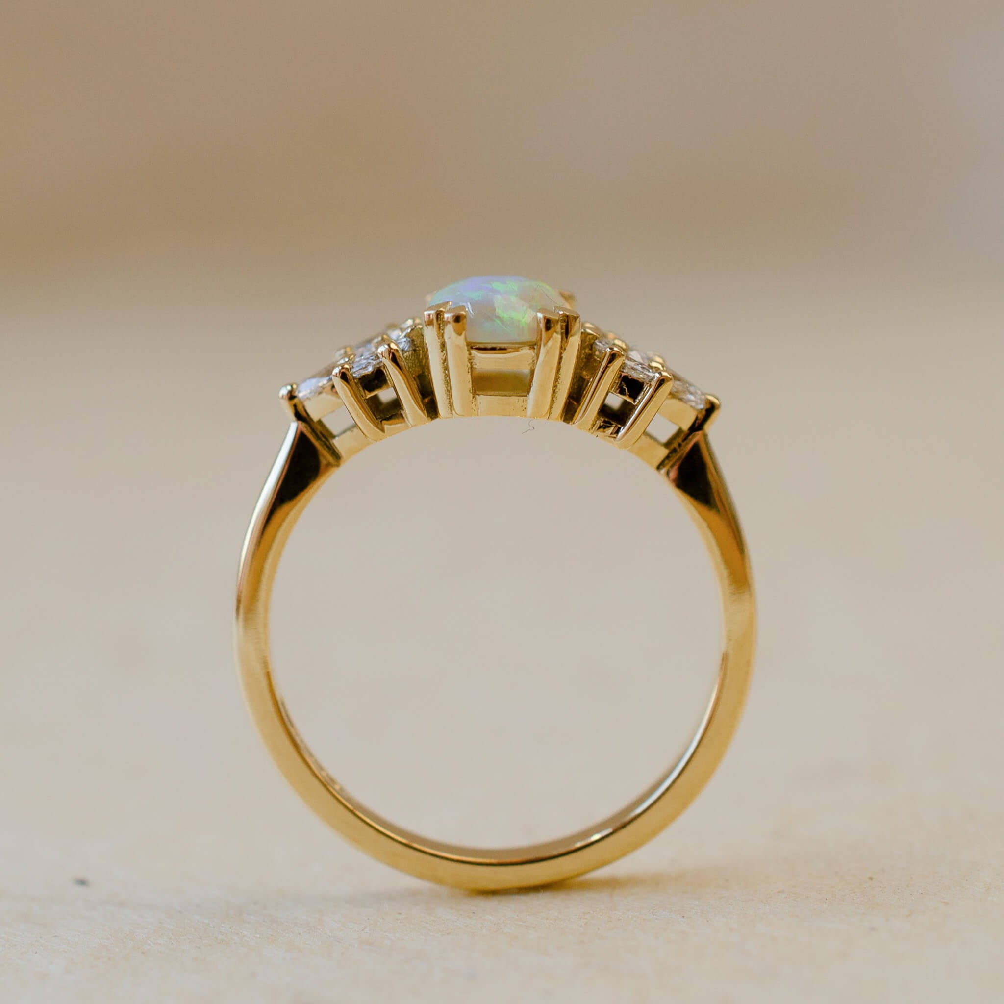 yellow gold ring with opal and diamond leaves on shoulders