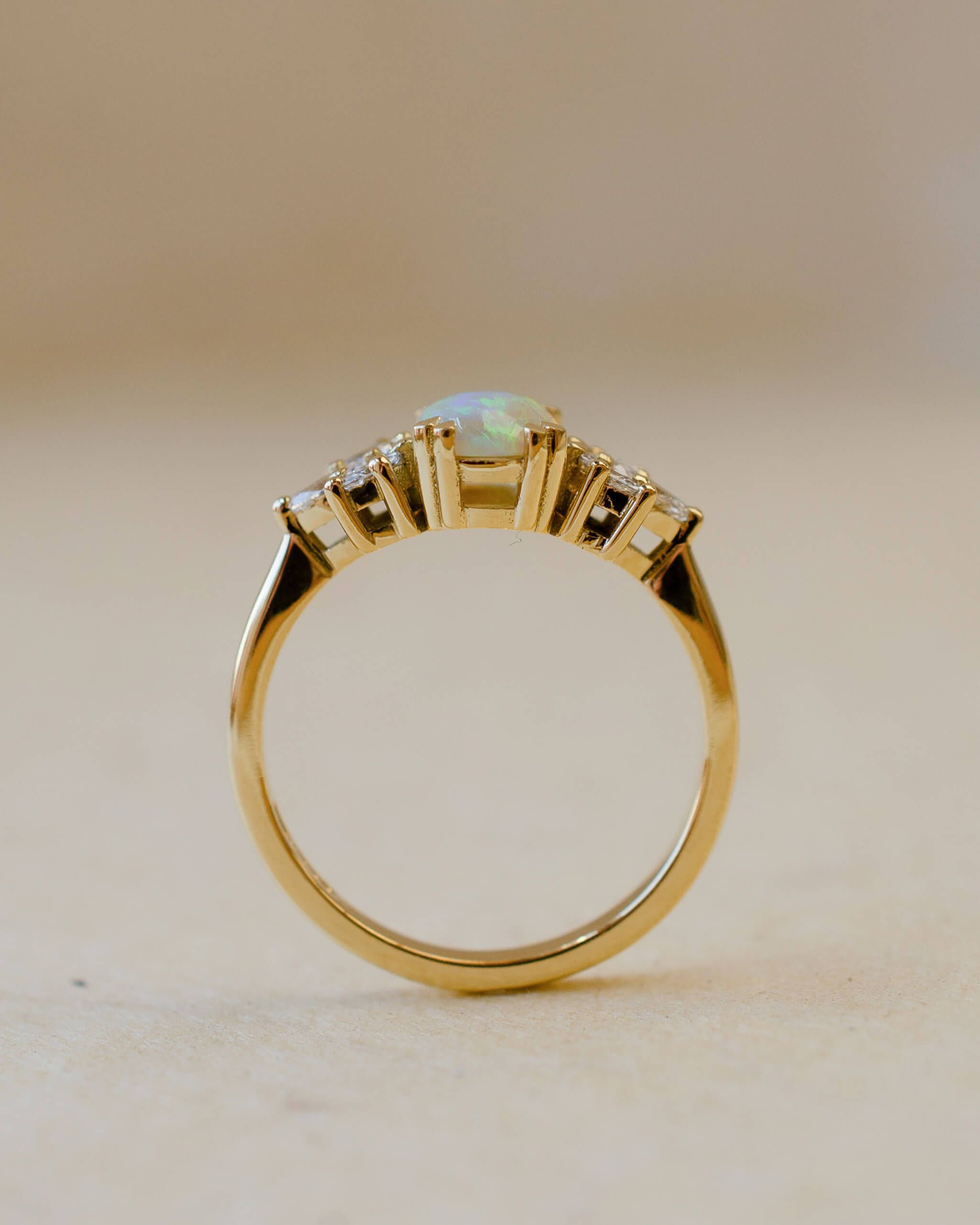 yellow gold ring with opal and diamond leaves on shoulders